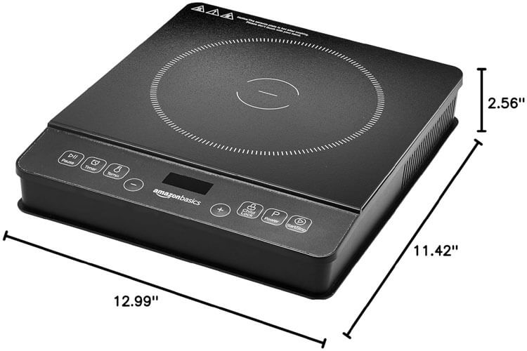 Amazon Basics 1800W portable induction cooktop with black tempered glass surface on small apartment counter