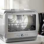 Are countertop dishwashers worth it? Countertop dishwasher on small kitchen counter with clean dishes visible through glass lid