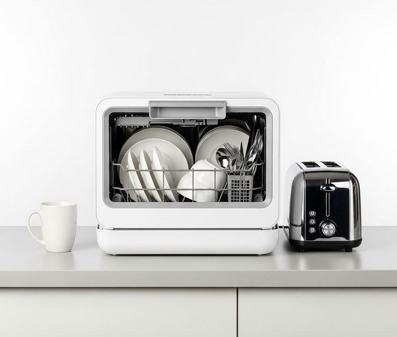 Countertop dishwasher next to coffee mug and toaster showing actual size for small kitchen counters