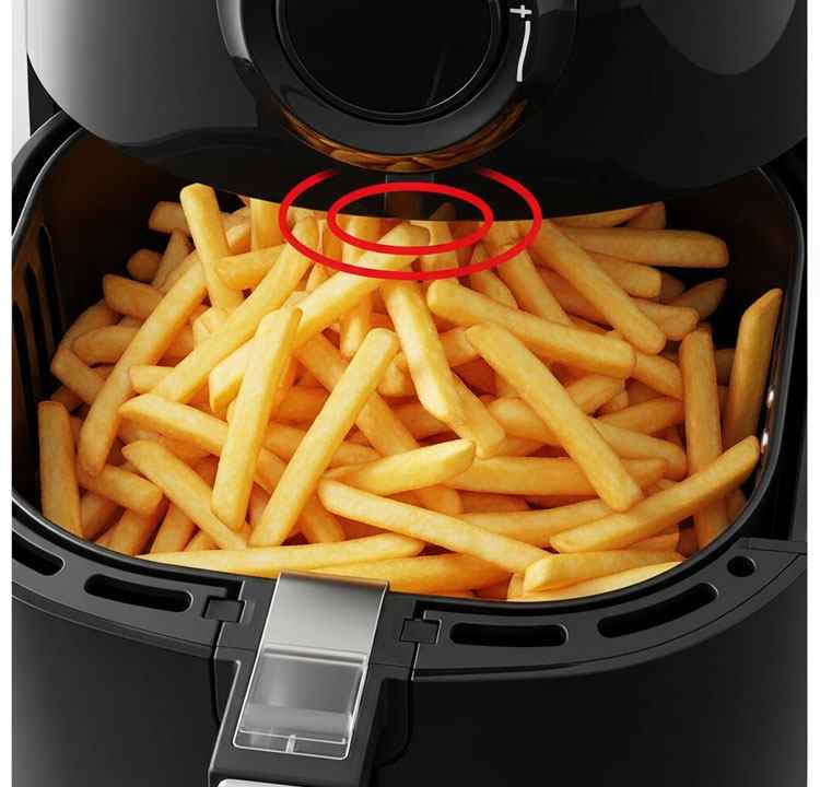 Overfilled air fryer basket with fries touching heating element causing smoke
